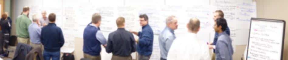 People standing in a conference room, in front of a white board