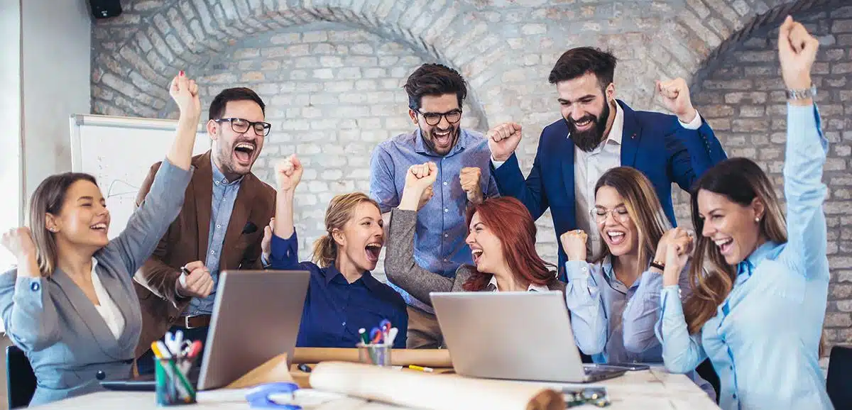 Business team cheering behind two laptops
