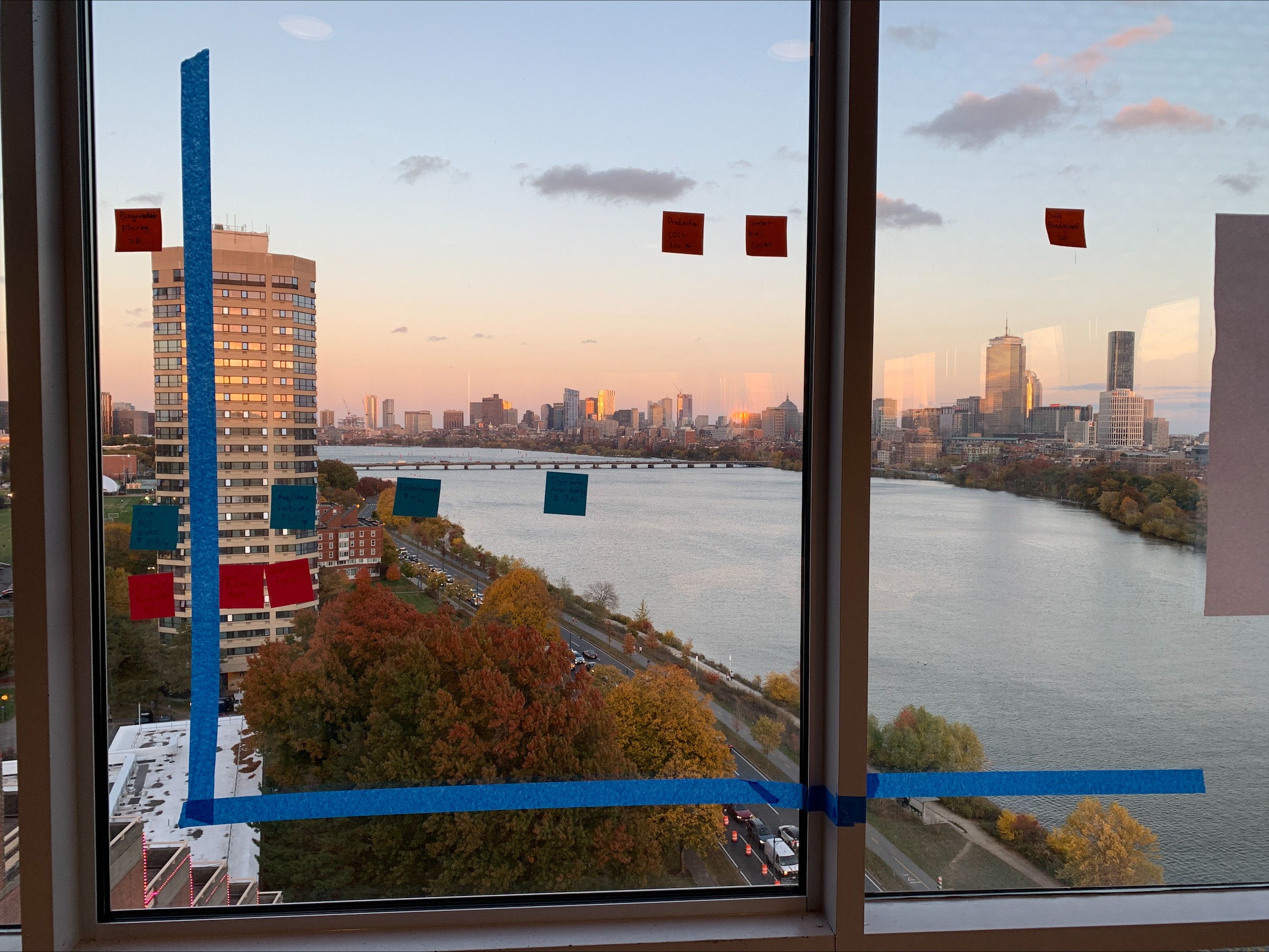 Paper prototype of our De-Risk Dashboard with an impressive view of the Charles River and Boston skyline  